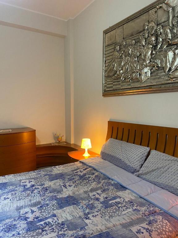 科森扎Luxury Room Cosenza的卧室配有一张床,墙上挂着一幅画