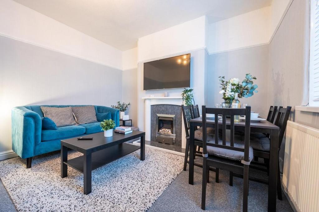 纽波特Dos Road by Tŷ SA的一间带蓝色沙发的客厅和一间用餐室