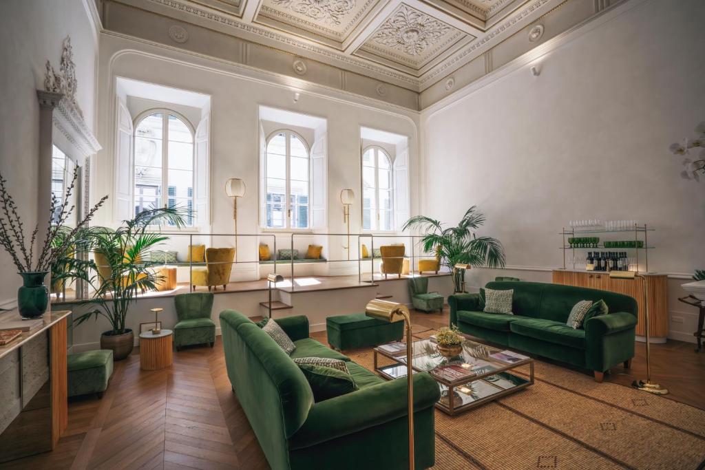 佛罗伦萨Casa G. Firenze的大型客厅设有绿色家具和窗户。