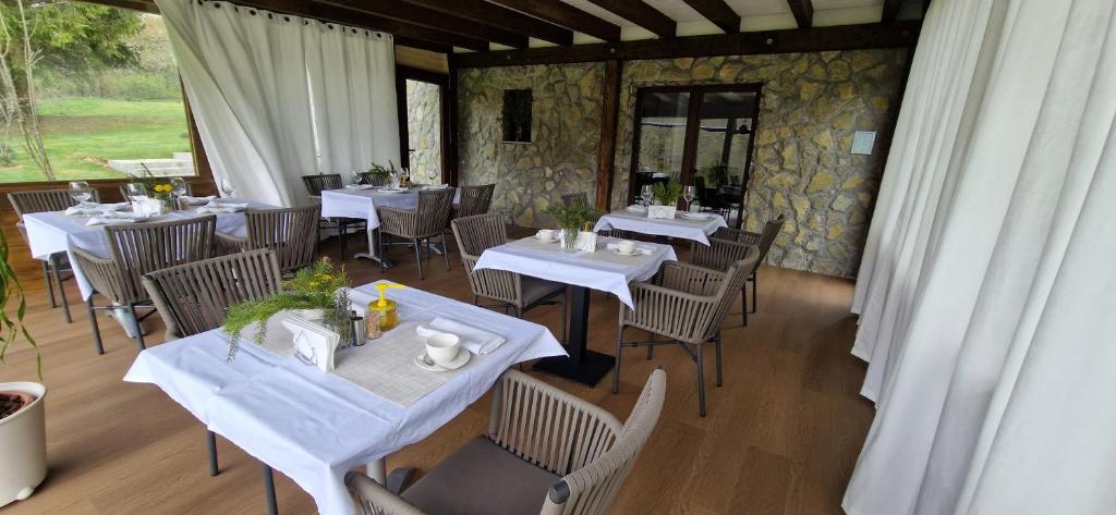 耶泽尔采Plitvice Inn的一间设有白色桌椅的用餐室