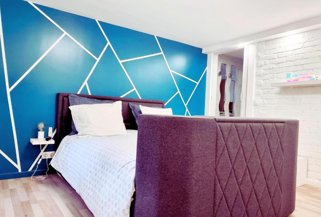 克劳德LA CAMPAGNE à PARIS的一间卧室设有一张床和蓝色的墙壁