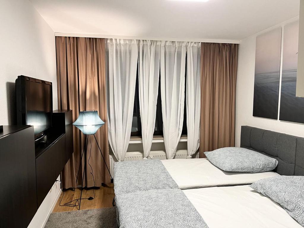 杜塞尔多夫Nice Apartment in Düsseldorf的酒店客房设有两张床和电视。