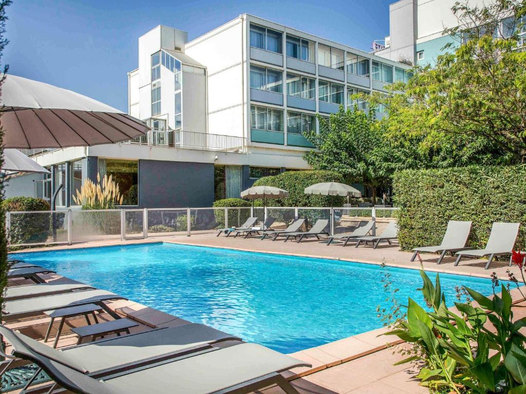 卡瓦永卡瓦永鲁伯隆门宜必思酒店的一座带躺椅的游泳池和一座建筑