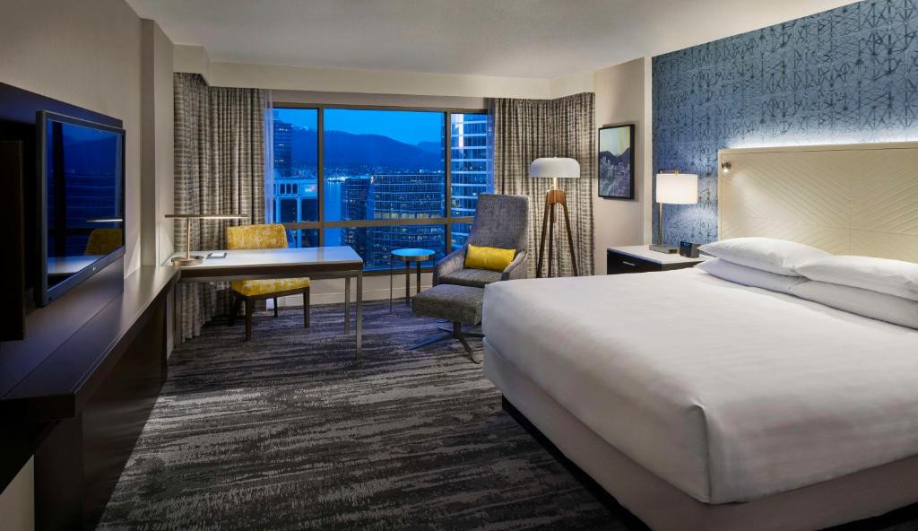 温哥华温哥华凯悦酒店的酒店客房设有一张床和一张书桌,享有美景。