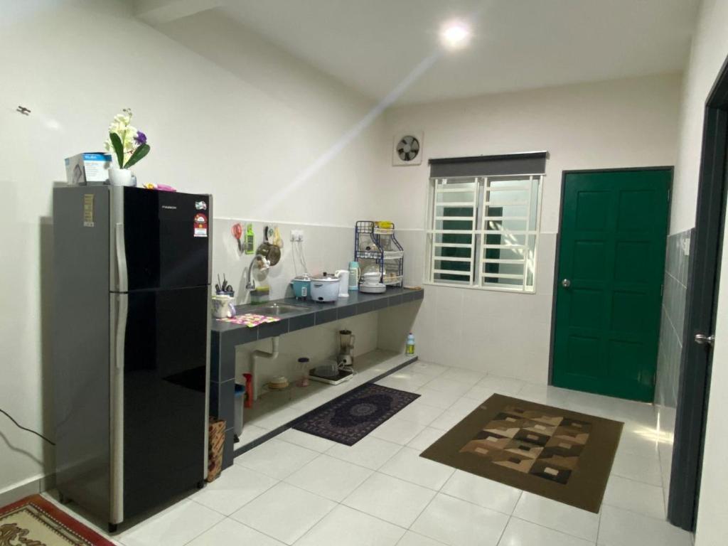 安顺Swedish Style Homestay的厨房配有黑色冰箱和绿门