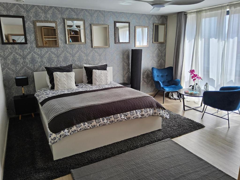 布鲁塞尔Chambre deluxe au 2ème étage, chambre double au 4ème étage PAS UN HÔTEL的一间卧室配有一张大床和一张蓝色椅子