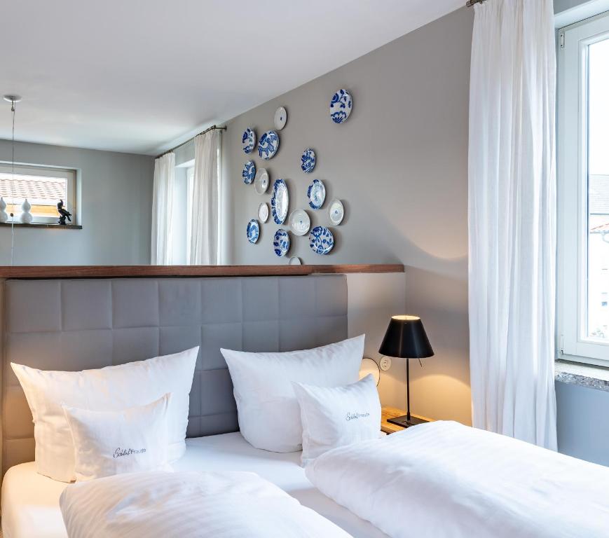 莱茵河畔凯尔Romantikhotel Rebstock art & design的卧室内的两张床,墙上挂着蓝色和白色的板子