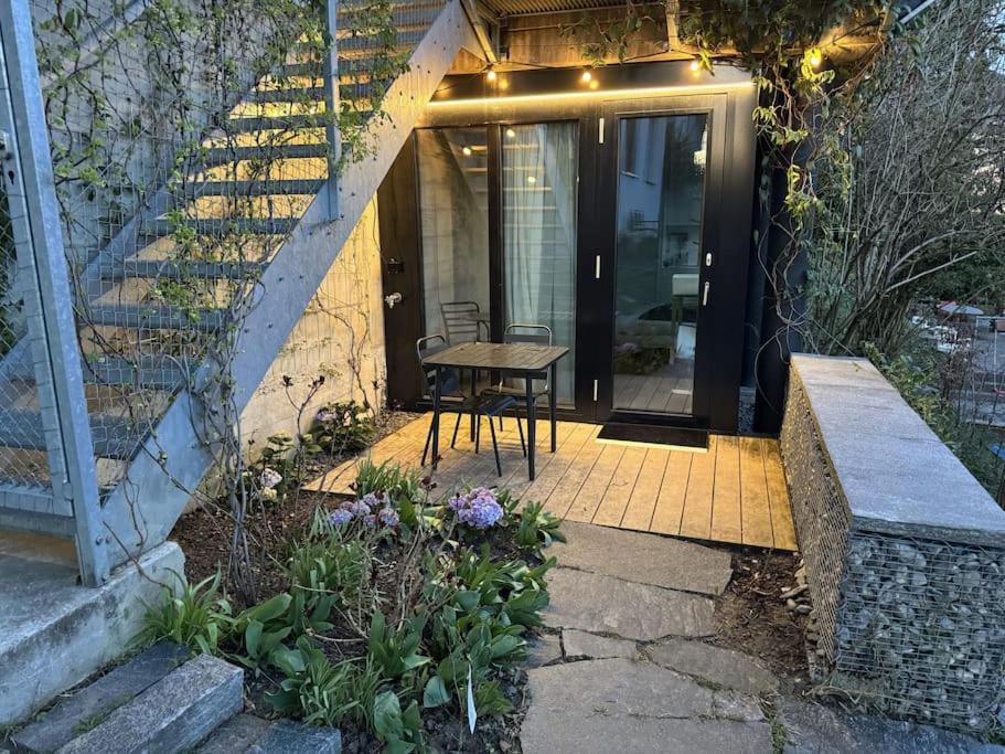 卢塞恩Charming Tiny Garden House for two的天井配有桌子和楼梯间
