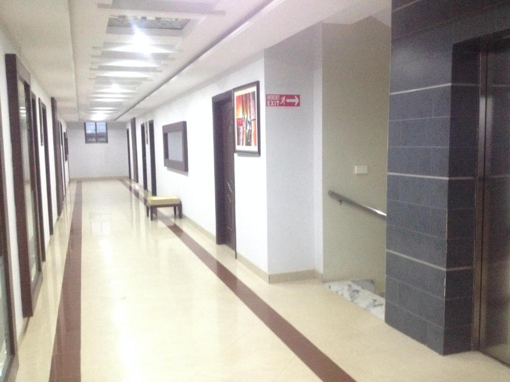 木尔坦Five Mounts Hotel And Restaurant的医院里一个空的走廊,有长凳