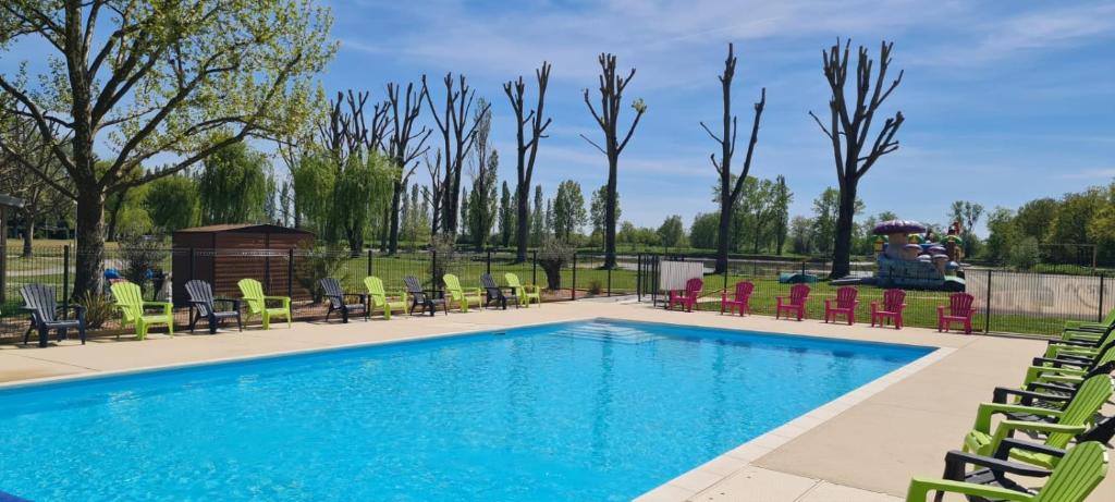 Ambérieux-en-DombesL'Oasis des Dombes的一个带椅子的游泳池以及一个喷泉