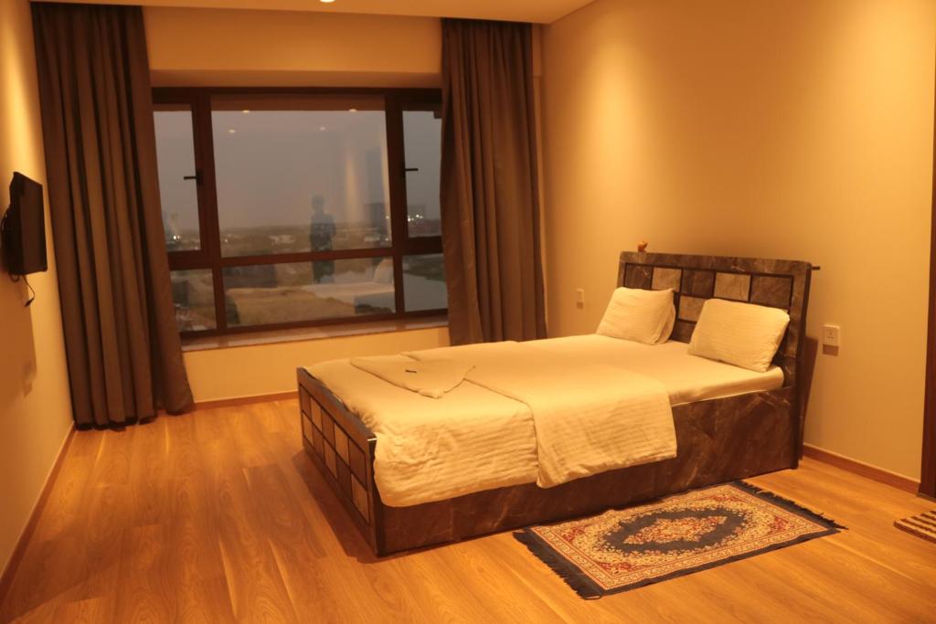 KharadiNiva Stays Riverside 1的一间卧室设有一张床和一个大窗户