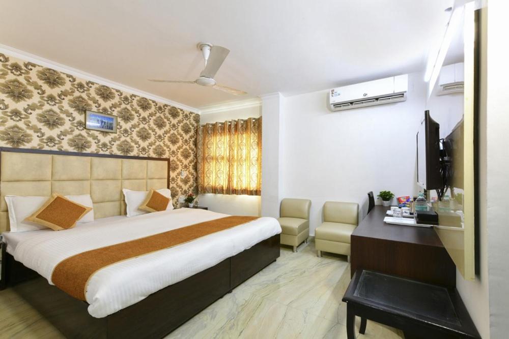 阿格拉Hotel First by Goyal Hoteliers的酒店客房,配有床和电视
