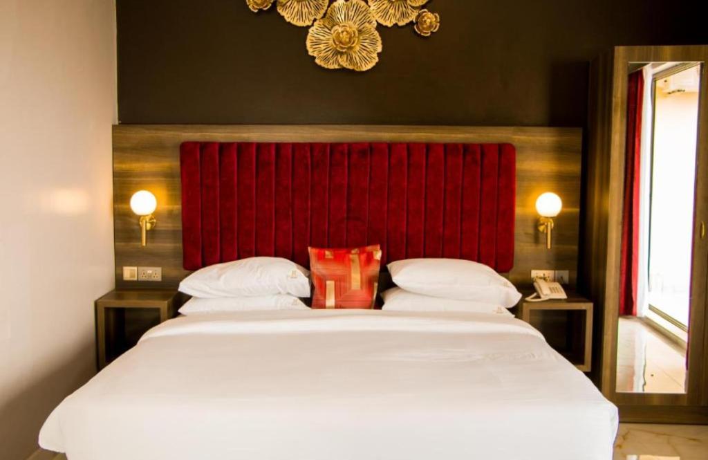 KisubiLake view property的一间卧室配有一张大床和红色床头板