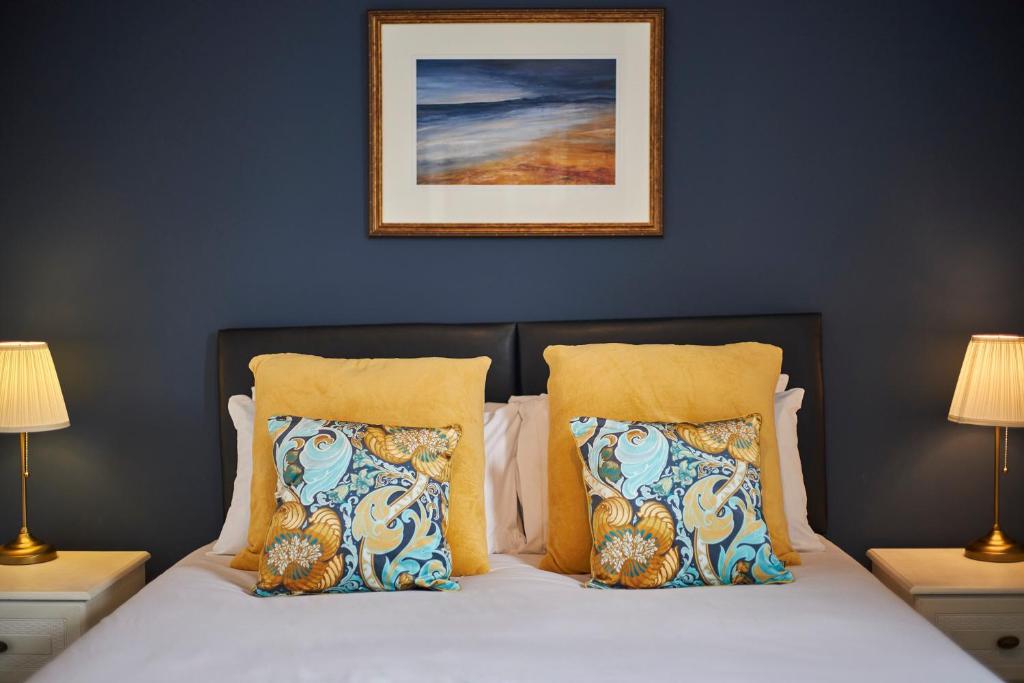 毕晓普奥克兰Cosy and convenient cottage的一张带两个枕头的床和一张墙上的照片