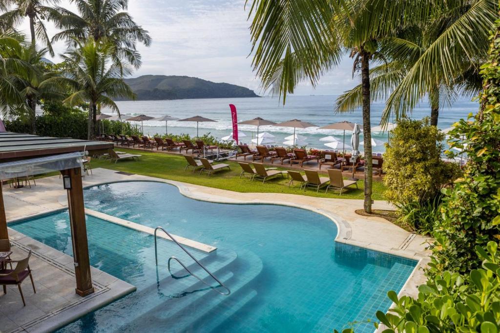 马利西亚斯Amora Hotel Maresias的一个带桌椅的度假村游泳池