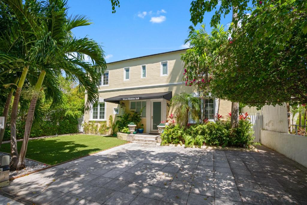 迈阿密海滩Villa Venezia BB full house up to 12 guests的棕榈树房屋和车道
