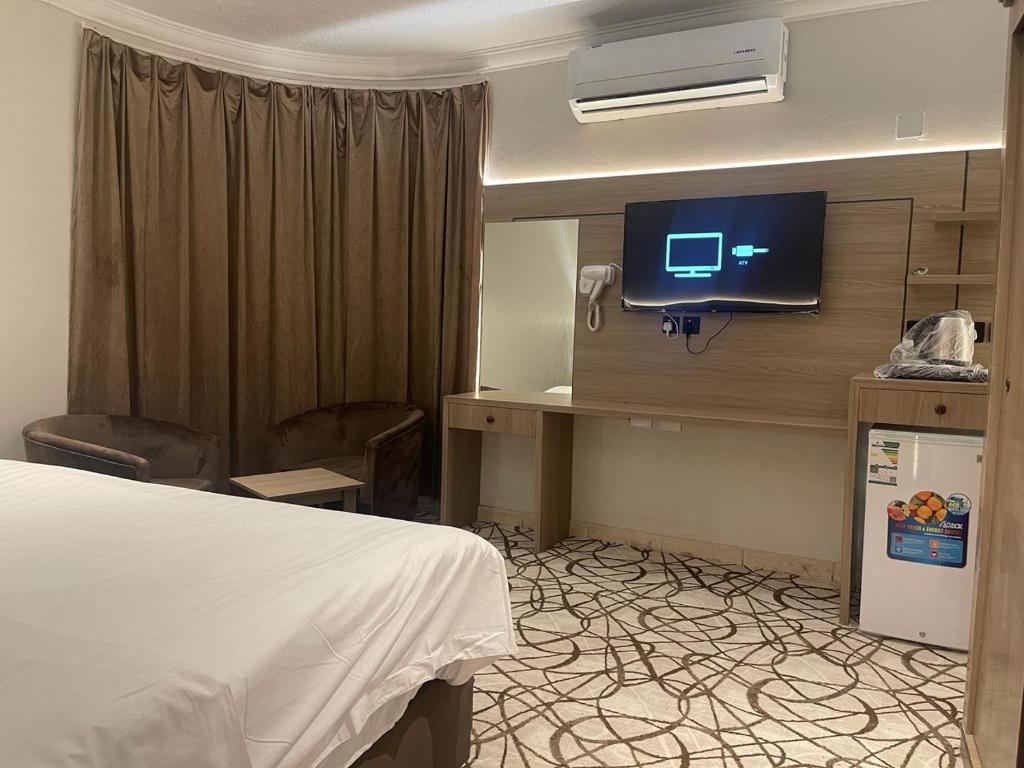 泰布克Dvina Hotel的一间酒店客房,配有一张床和一台墙上的电视