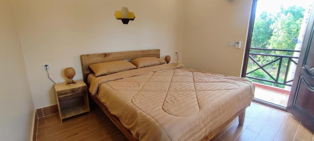 Phumĭ Chroŭy SvayCare Rock Guesthouse的一间卧室设有一张床和一个大窗户