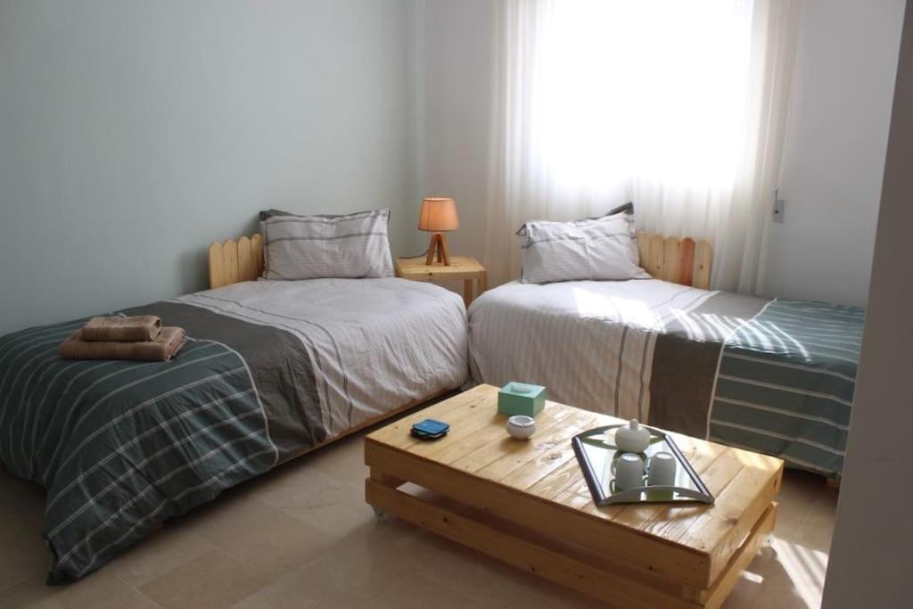 斯法克斯Appartement simple et propre的客房设有两张床和一张茶几