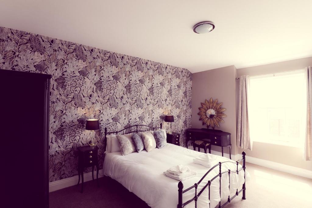 阿尔弗斯顿太阳旅馆的一间卧室配有一张带花卉壁纸的床