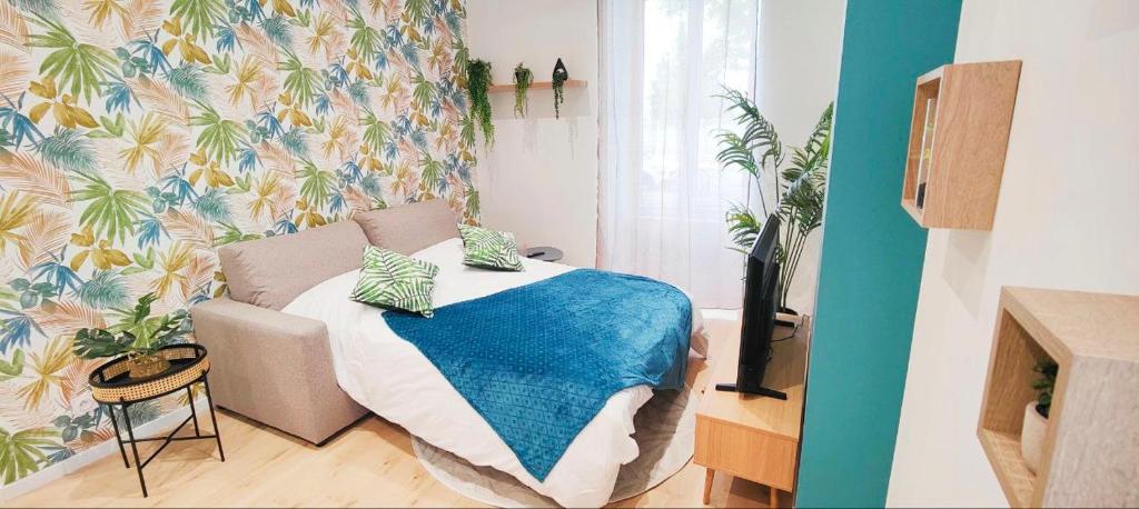 克莱蒙费朗Appartements à thème的一间卧室配有一张带蓝色毯子的床