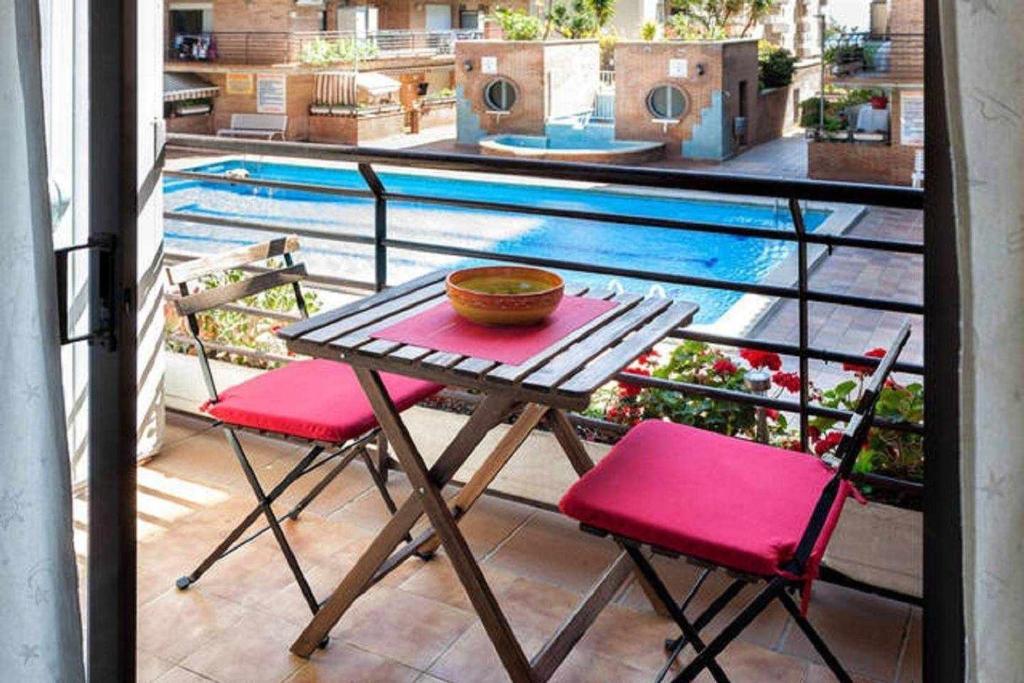 皮内达德马尔P2 TARAyPAUL 4 PAX PINEDA DE MAR的一个带游泳池的阳台,配有一张桌子和两把椅子