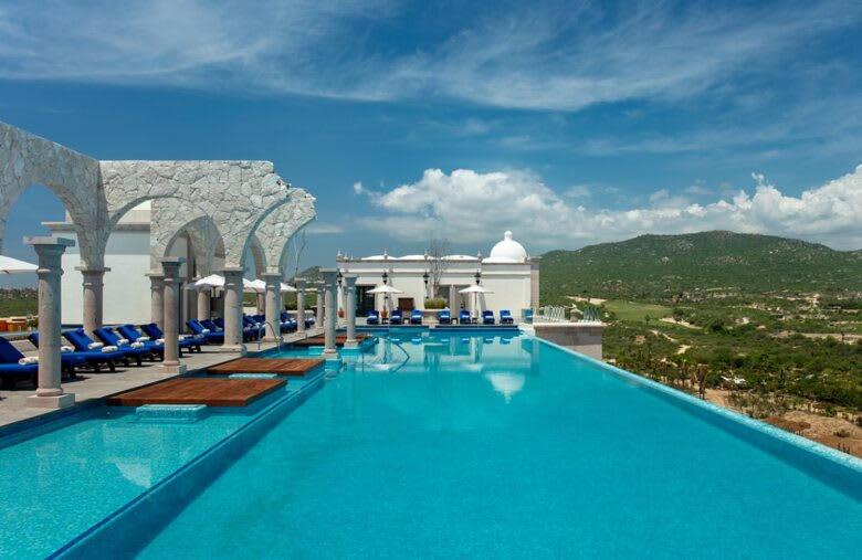 卡波圣卢卡斯2BD Hacienda Vista Suite Plunge Pool & Ocean View的度假村内的大型游泳池,配有蓝色椅子