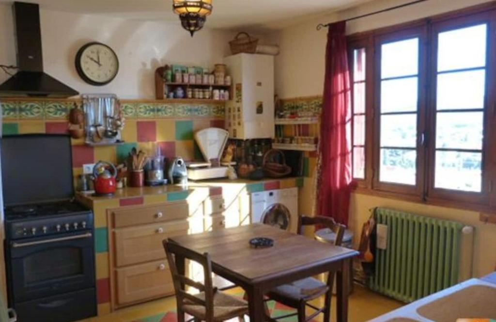 拉西约塔Chambre paisible proche calanques et centre La Ciotat的厨房配有桌子和墙上的时钟