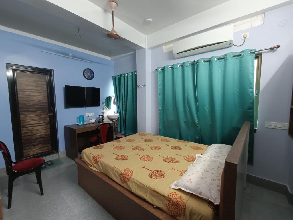 阿加尔塔拉Ujjayanta Homestay的一间卧室配有一张床、一张书桌和一台电视
