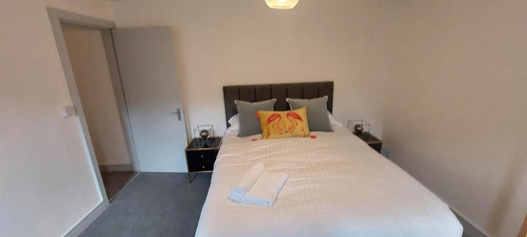 马基特雷森2 Bedroom Modern Living in The Old Bank House in Market Rasen的卧室配有一张白色大床和黄色枕头