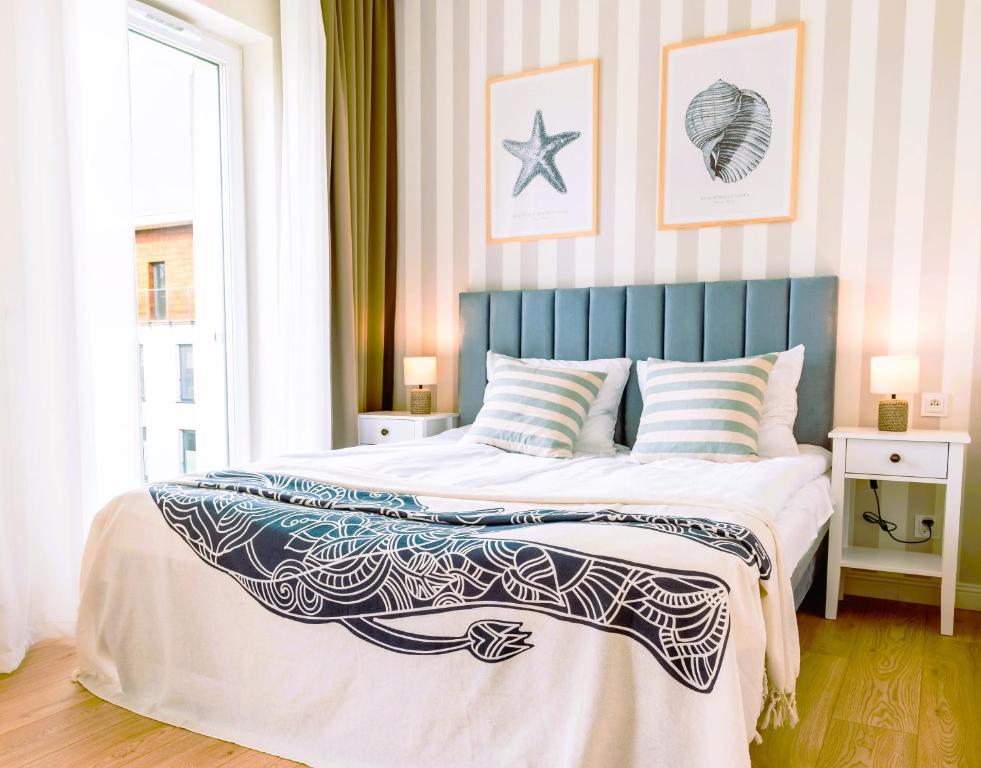 伊拉华Marina Nautica z prywatnym parkingiem podziemnym的一间卧室配有一张大床和蓝色床头板