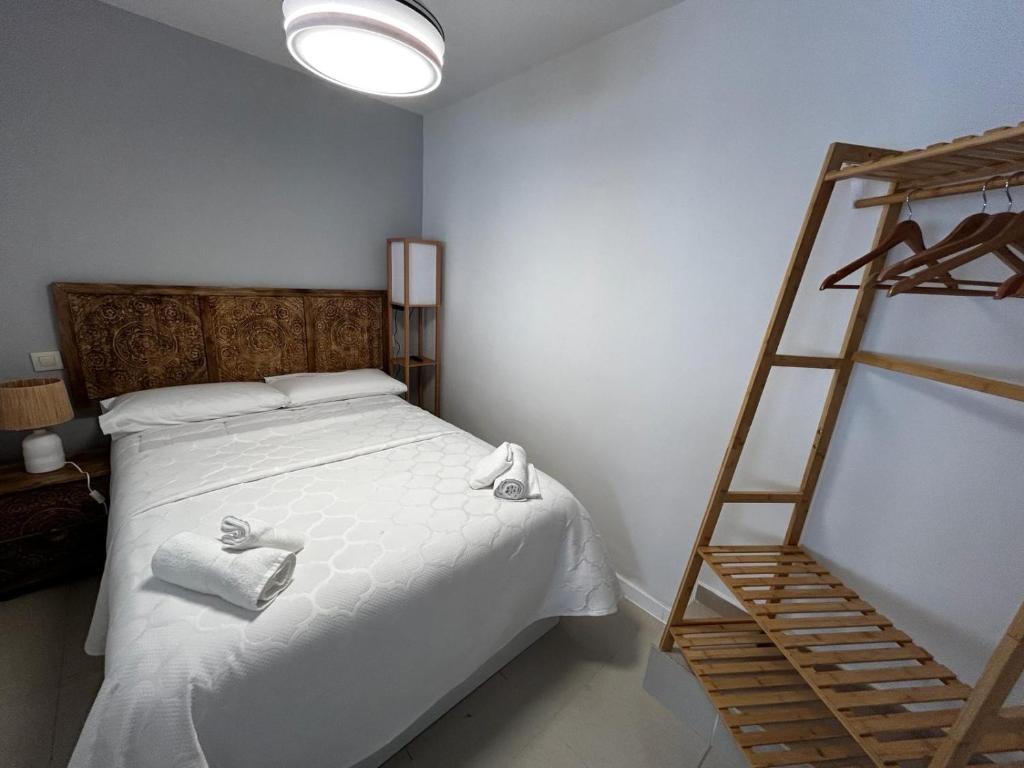 Los YébenesCasa Eliseo的一间卧室配有一张带两条毛巾和梯子的床
