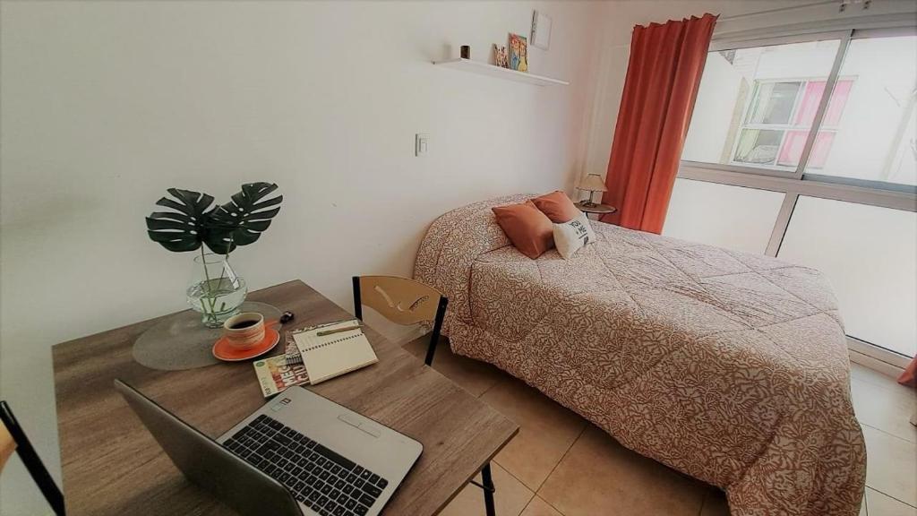 罗萨里奥Hornera Balcarce - Depto estudio Cerca de todo的一间卧室配有一张床和一张带笔记本电脑的书桌