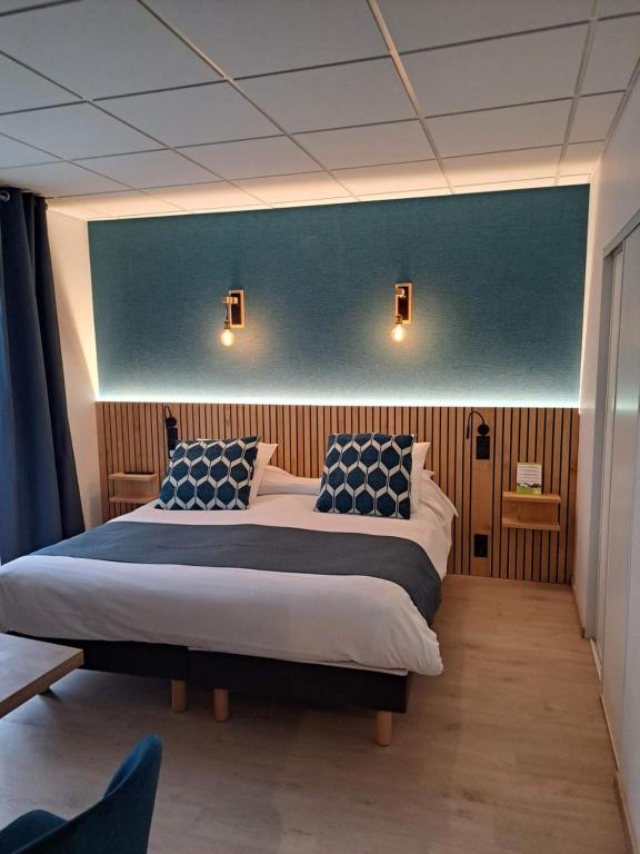 圣热涅-多尔特金狮酒店的一间卧室设有两张床和蓝色的墙壁