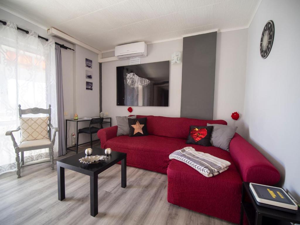 圣克鲁斯-德特内里费Laurent Suite的客厅配有红色的沙发和桌子