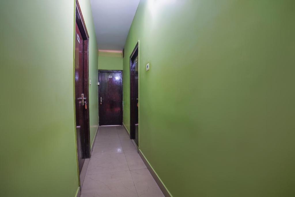 鲁德拉普尔SPOT ON Komfort Guest House的一条空的走廊,有绿色的墙壁和门