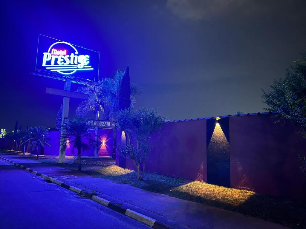 平达莫尼扬加巴Motel Prestige Pinda的大楼一侧有 ⁇ 虹灯标志的餐厅