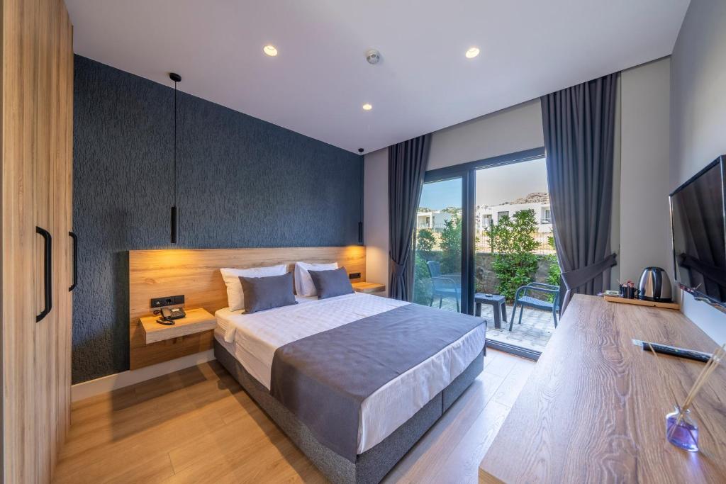 博德鲁姆Gündoğan Suites的一间卧室配有一张大床和电视