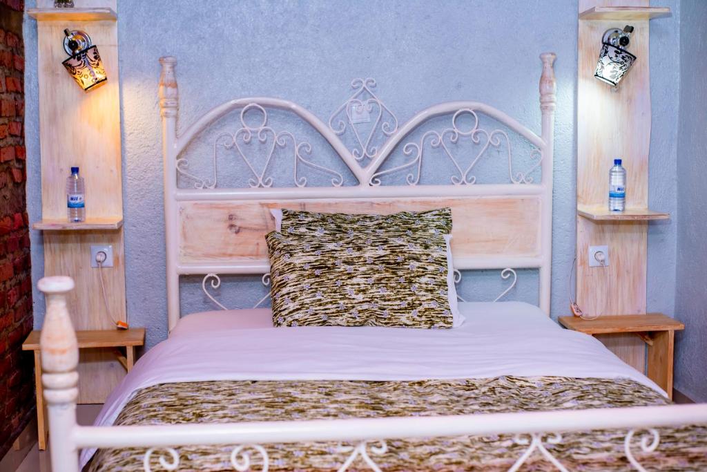 鲁亨盖里Little Birds Paradise的卧室配有白色的床和木制床头板