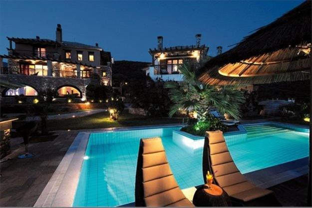 科罗皮埃克瓦吉斯套房&Spa酒店的一座带躺椅的游泳池位于大楼旁