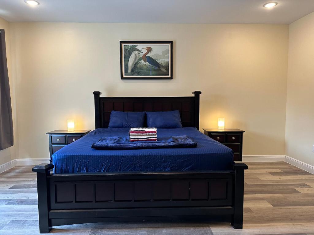坦帕River Palace的一间卧室配有一张带蓝色床单的床和2个床头柜。