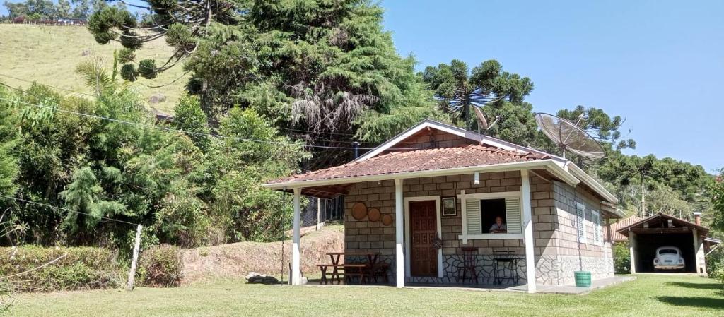 贡萨尔维斯Canto dos Pássaros- Casa de campo em Gonçalves的小房子,配有桌子和窗户