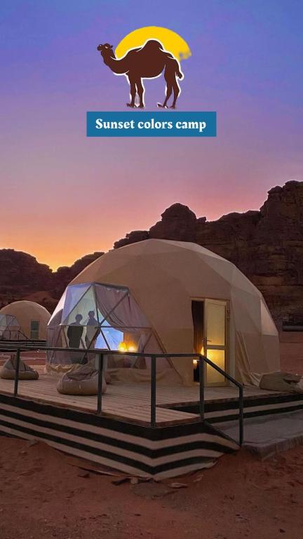 瓦迪拉姆Sunset colors camp的沙漠中带骆驼雕像的圆顶帐篷