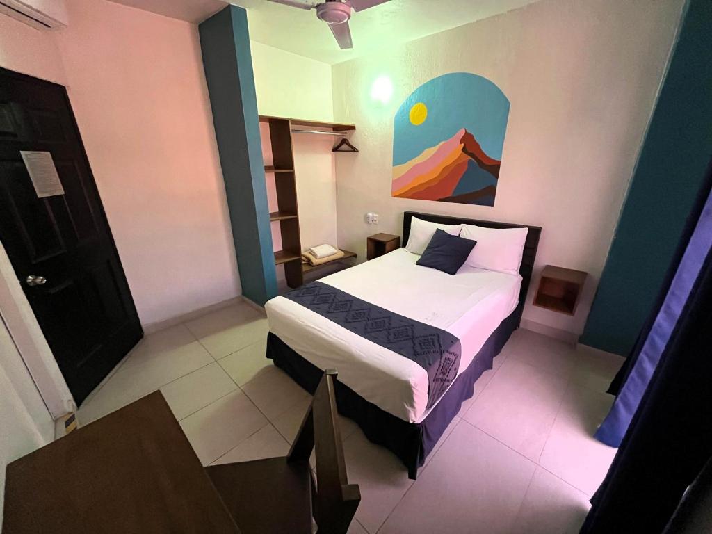 科利马Hotel Juarez 70的卧室配有一张床,墙上挂有绘画作品