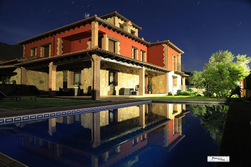 洛萨尔德拉韦拉Casa Rural La Canchalera的一座大房子,前面设有一个游泳池