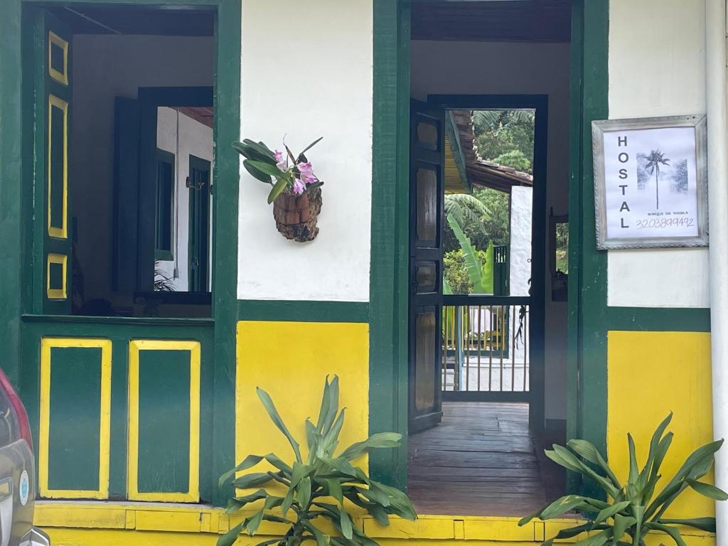PijaoBOSQUE DE NIEBLA的绿色和黄色的前门房子