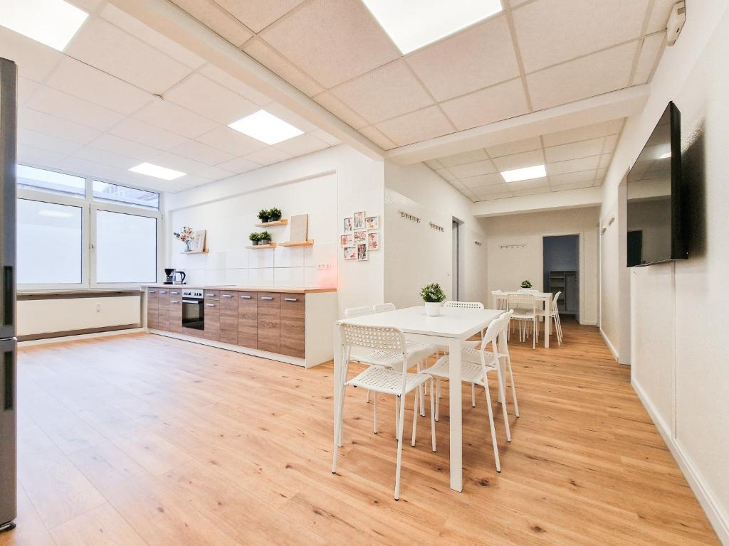 杜塞尔多夫RAJ Living - City Apartments with 5 Rooms - 10 Min Messe DUS的厨房以及带白色桌椅的用餐室。