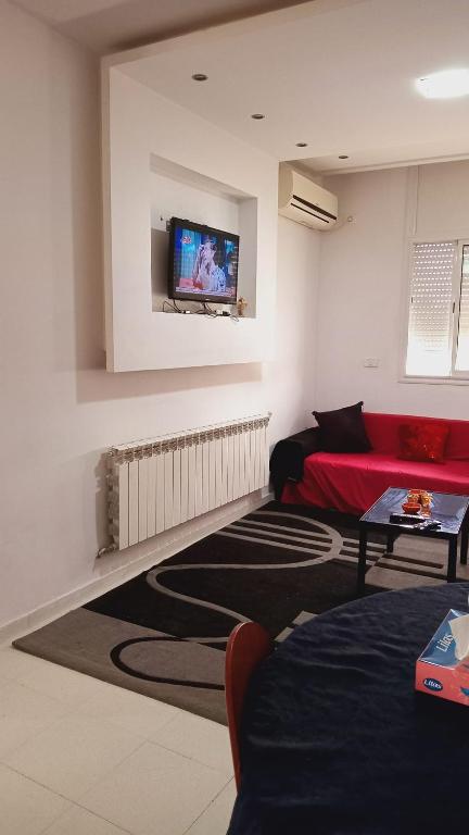 Chott MeriemKalthoum的客厅配有红色沙发和平面电视