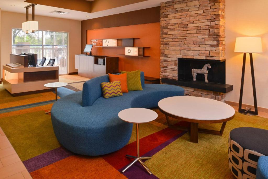 奥兰多奥兰多机场费尔菲尔德客栈的客厅设有蓝色的沙发和壁炉