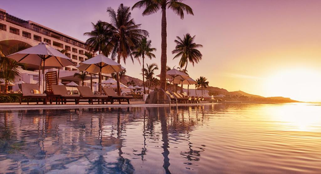 圣何塞德尔卡沃Marquis Los Cabos, an All - Inclusive, Adults - Only & No Timeshare Resort的一个带椅子和棕榈树的度假游泳池以及大海